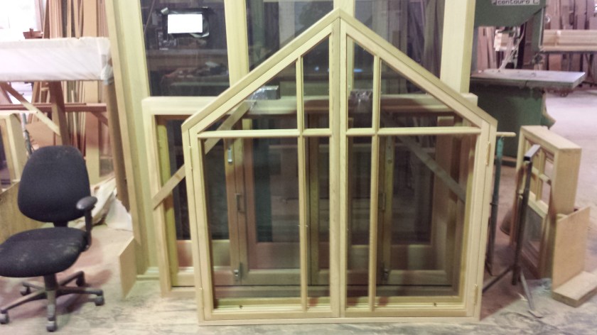 Peaked casement window with colonial bars.