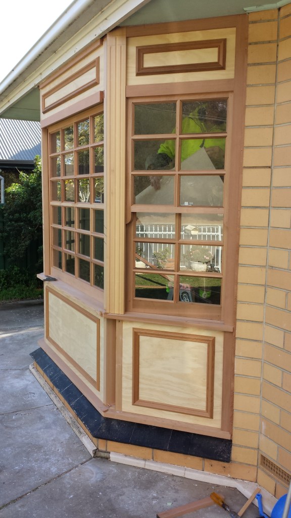 WRC bay window with colonial bars, and timber paneling.
