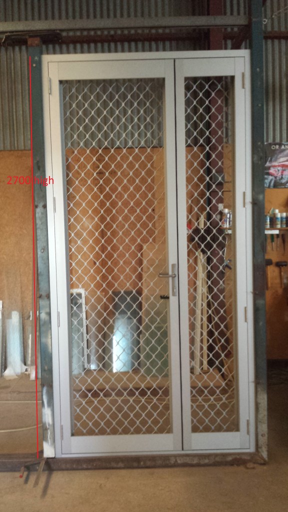 2.7m high clear anodise commercial french doors with security screen doors inside. The Active door is larger than the inactive door. To be glazed on site.