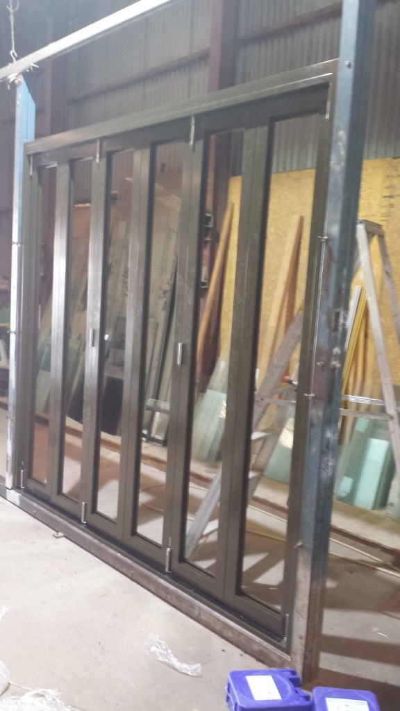 Aluminium Bifold door. Sitting in our factory jig to ensure the doors operate perfectly before being sent out on site.