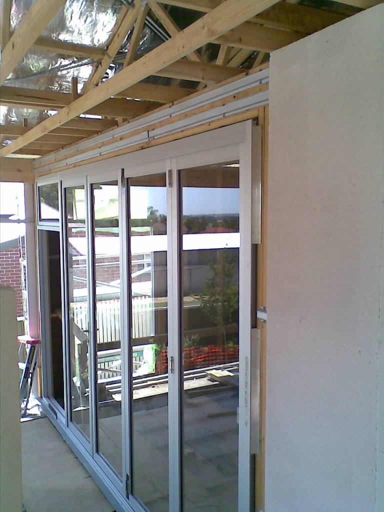 Clear anodise bifold door with awning window on top of active door.